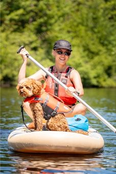 Jeune femme et son chien sur planche à pagaie chez Canots Légaré